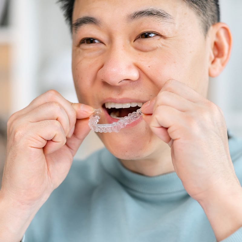 Invisalign patient in Boston putting in their aligners