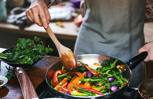A woman cooking stir-fried vegetables