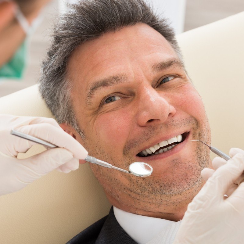 Man leaning back and smiling during dental exam