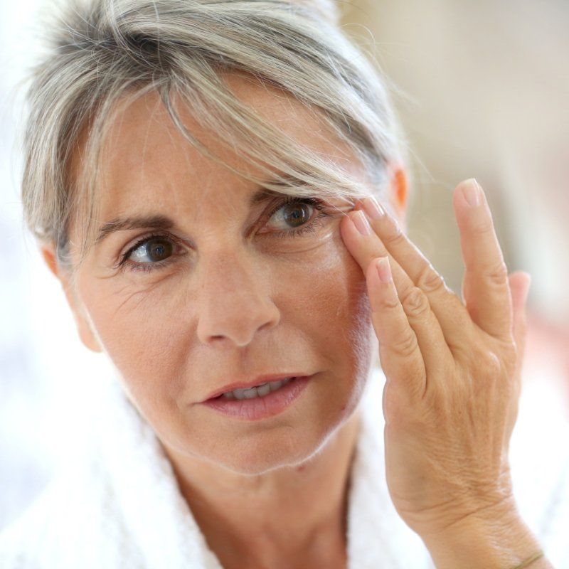 Close up of woman checking face in mirror