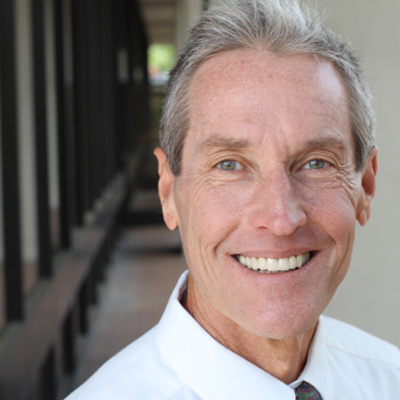 Man smiling outside an office building