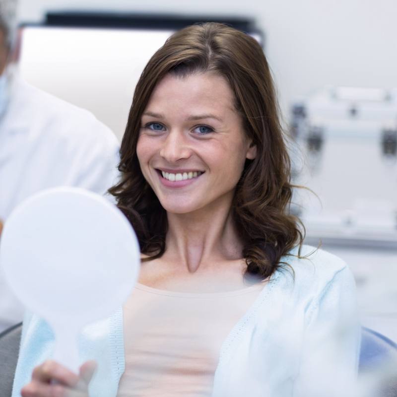 Female patient sitting in dental chair smiling