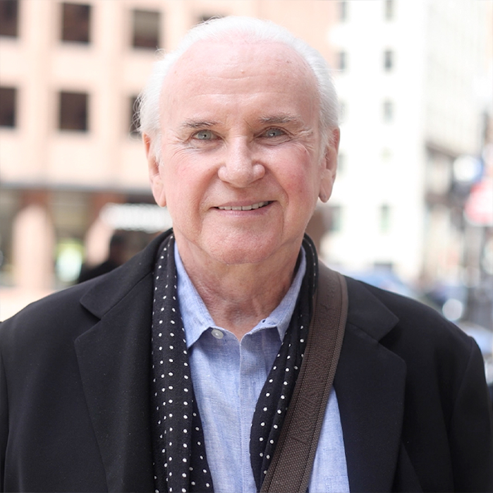 Older man walking down street and smiling