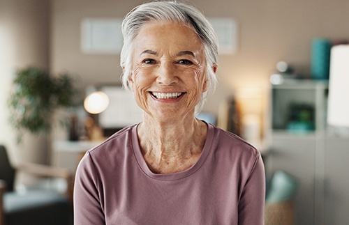 Older woman wearing purple shirt and smiling