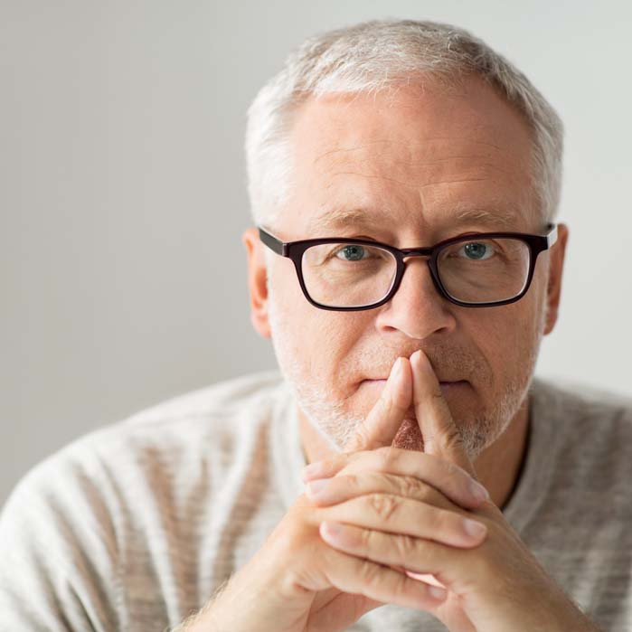 Man with glasses looking thoughtful