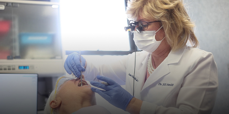 Dentist with mask treating a patient