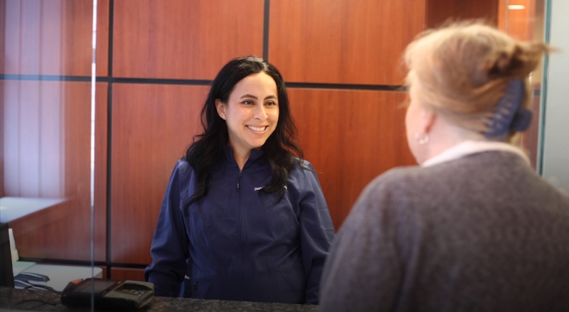 Smiling woman talking to another woman at a table