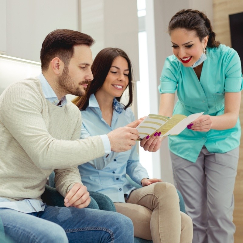 Dentist showing couple an insurance form