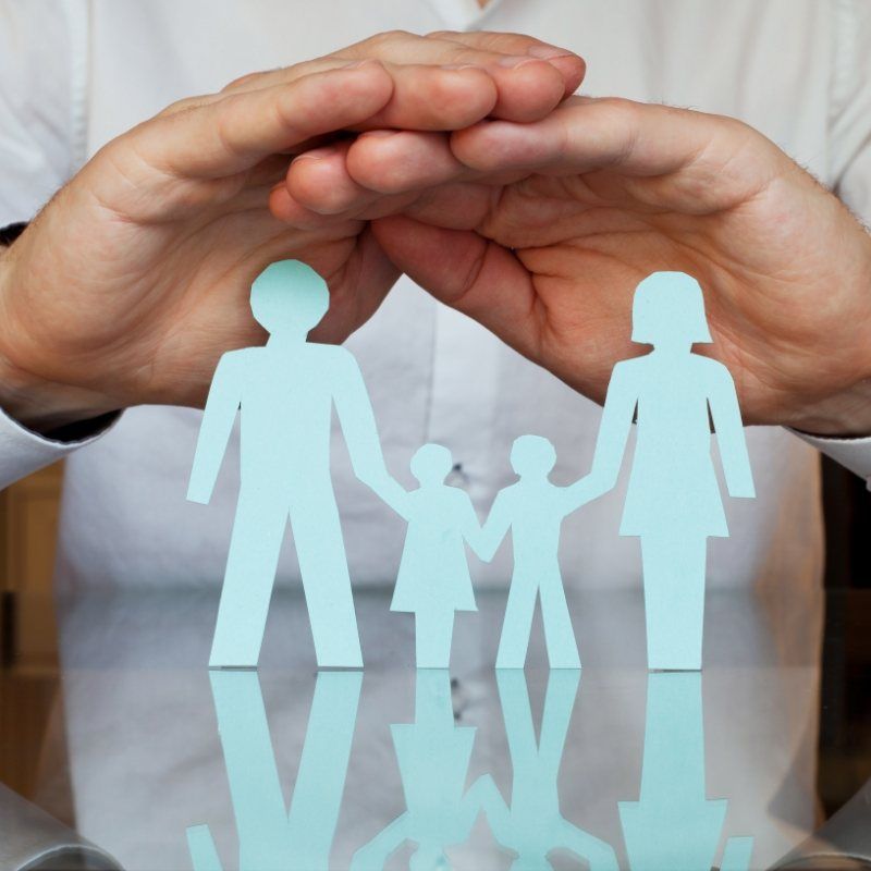 Hands over cutout of a family