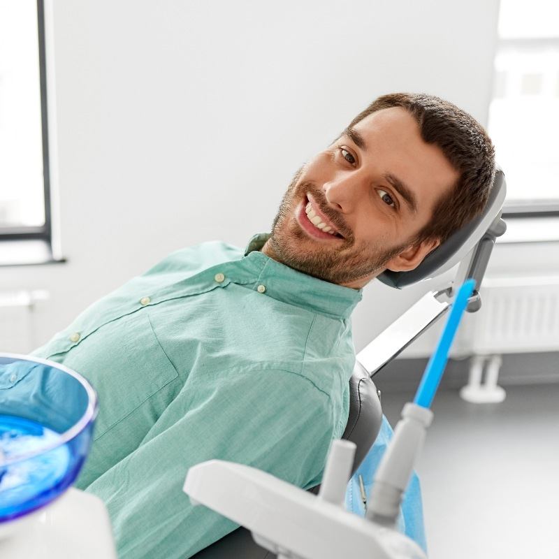 Male dental patient leaning back and smiling