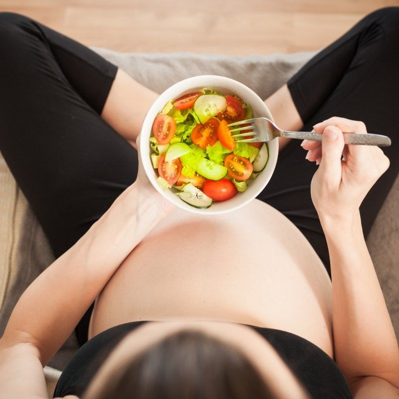 Pregnant woman eating a salad