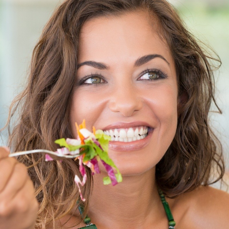 Smiling woman eating a salad