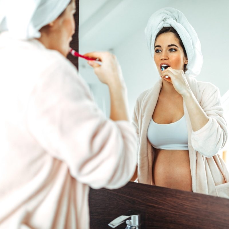 Pregnant woman brushing her teeth