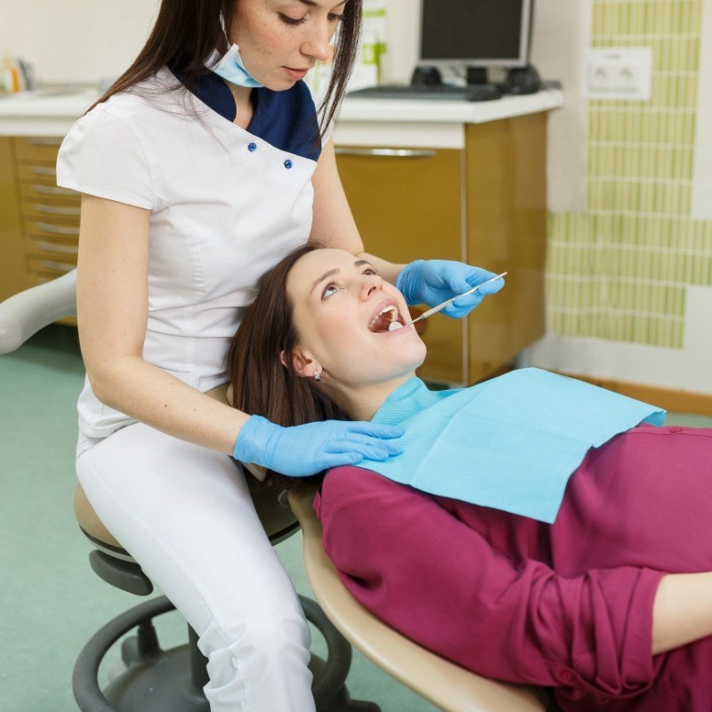 Woman having teeth examined by female dentist