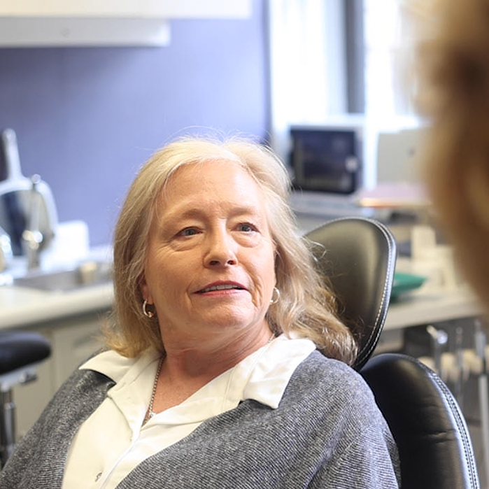 Senior female dental patient looking at dentist