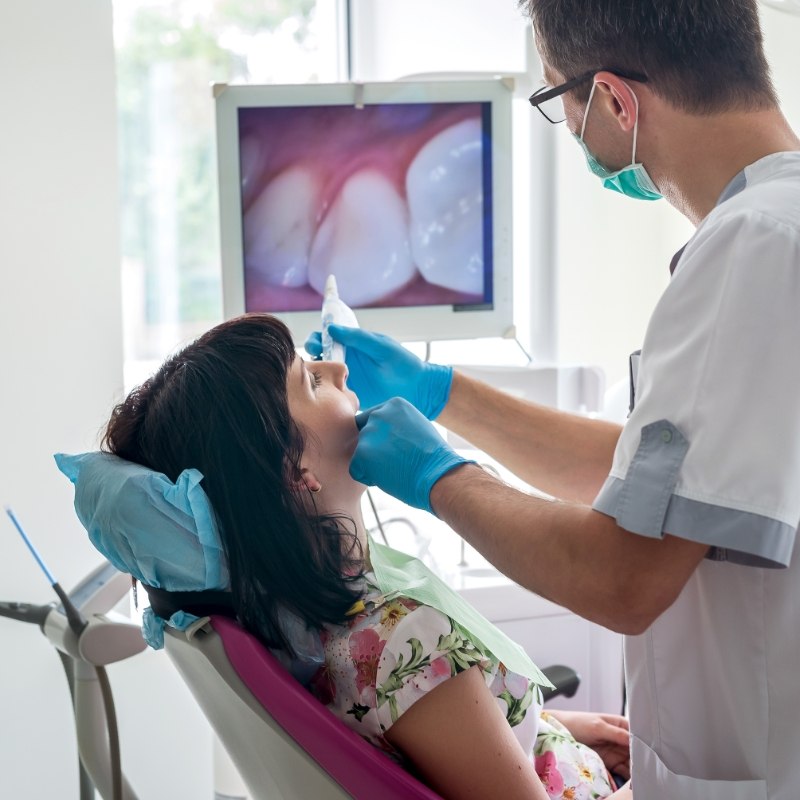 Dentist examining patients mouth with intraoral camera