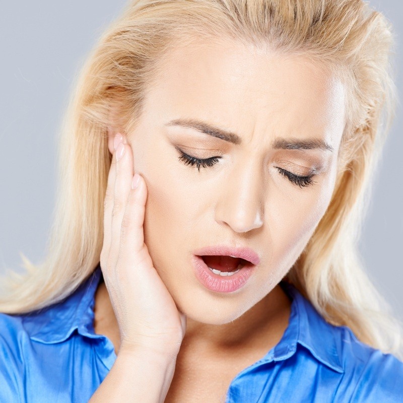 Blonde woman with jaw pain needing TMJ treatment in Boston