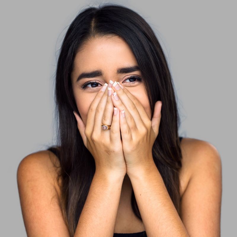 Woman with black hair covering her mouth