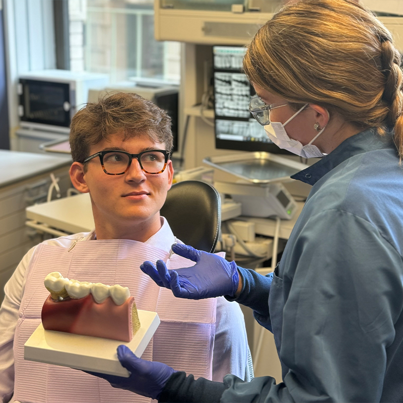 Worried woman at dental office covering her mouth