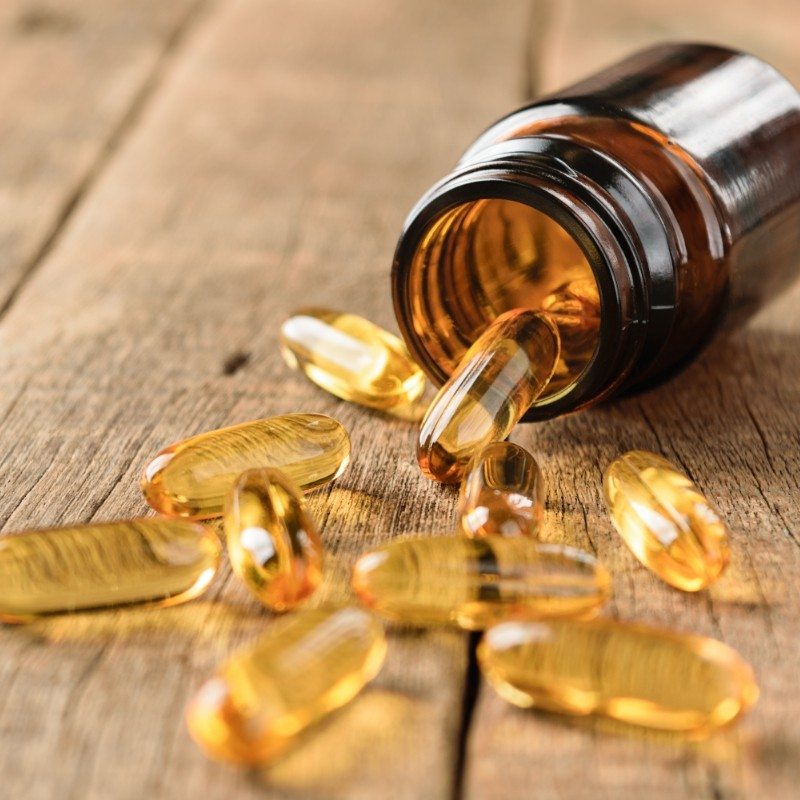 Close up of supplements and bottle on wooden table