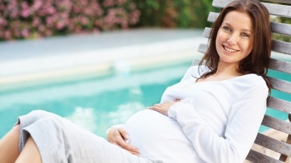 pregnant woman lounging next to the pool