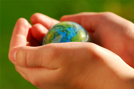 a pair of hands holding a miniature globe