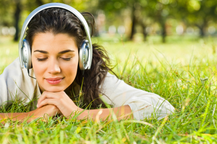 woman with headphones on in a field